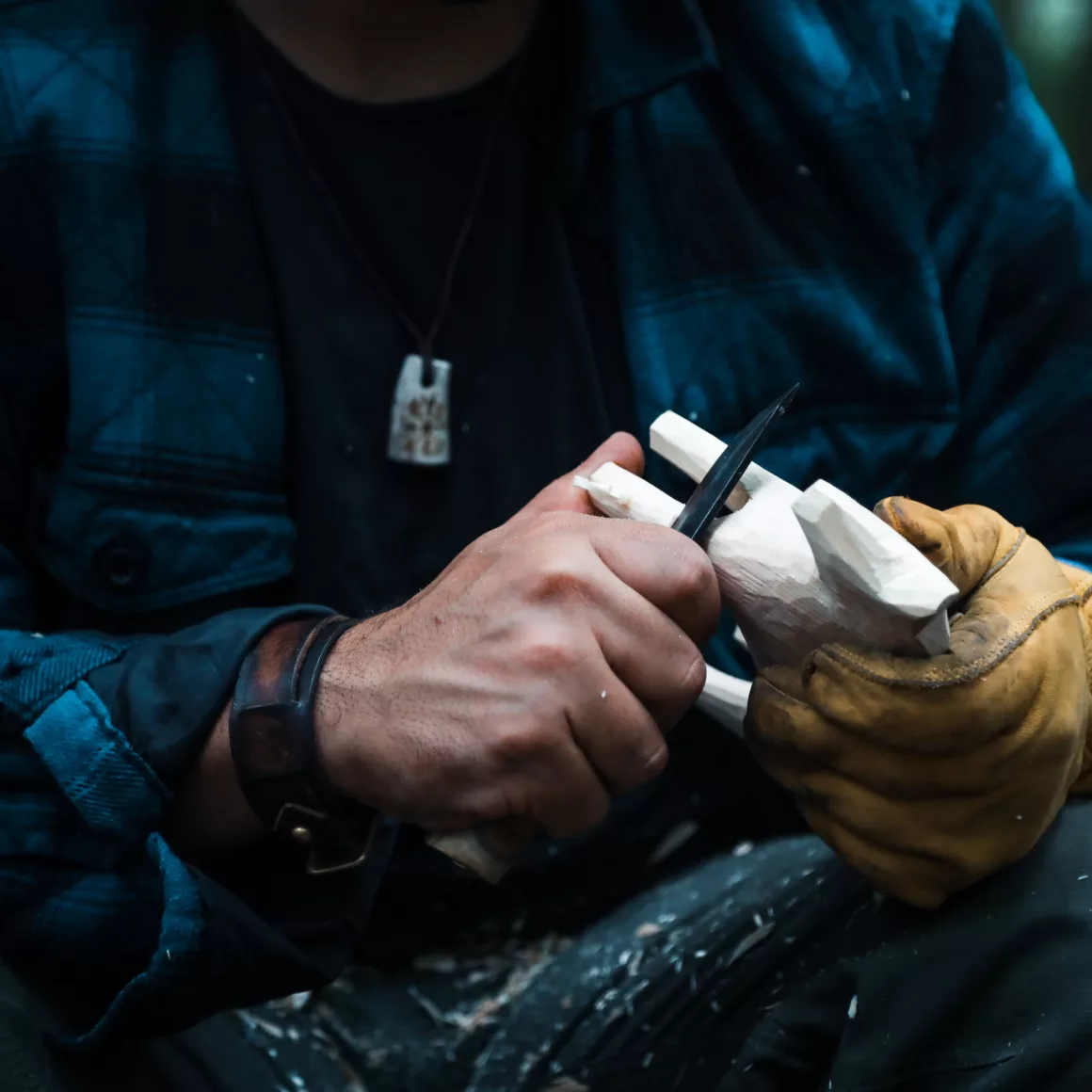 Close up of man carving branch with knife in nature